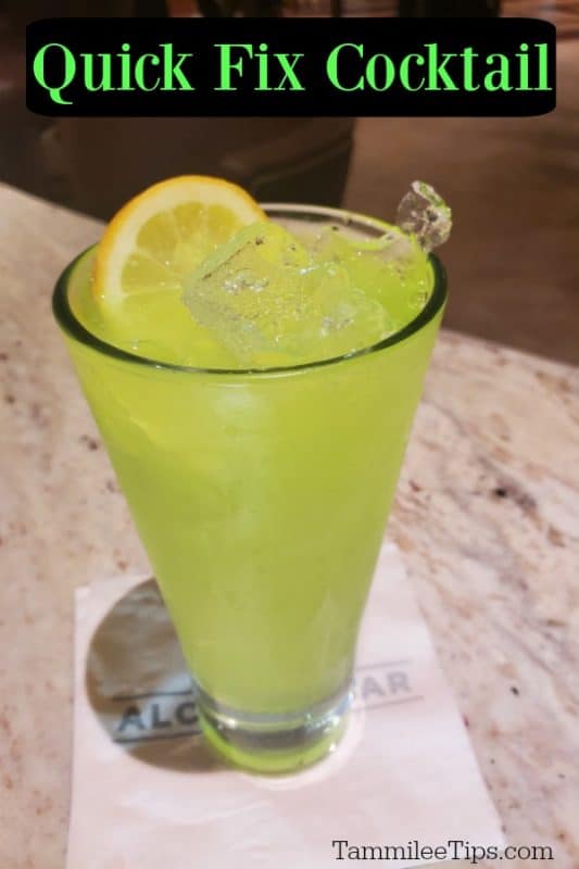 bright green cocktail in a tall glass with a white napkin