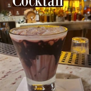 Deal Closer cocktail printed over a filled glass and Alchemy Bar napkin