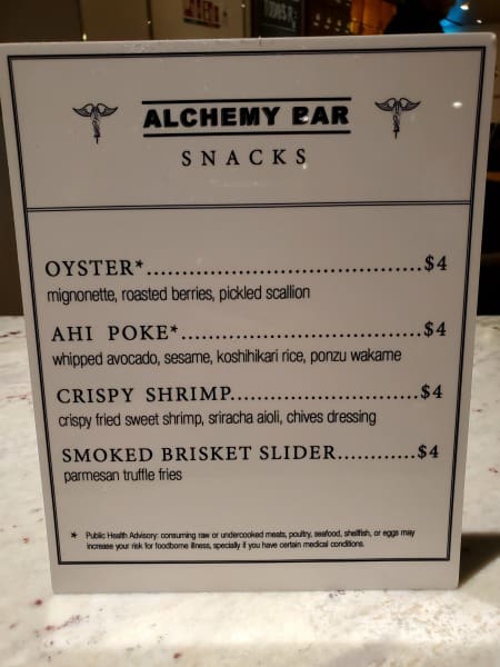 Alchemy Bar snacks menu with oysters, ahi poke, crispy shrimp, and smoked brisket slider