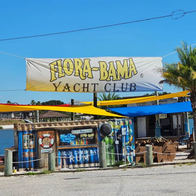 Flora Bama Yacht Club Sign over a Blue Chair Bay Rum Bar sign