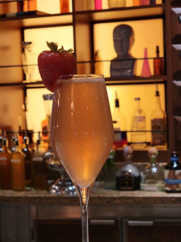 French Kiss Cocktail champagne flute with a strawberry garnish