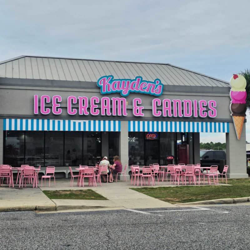 Kayden's Ice Cream and Candies entrance sign with pink tables and chairs