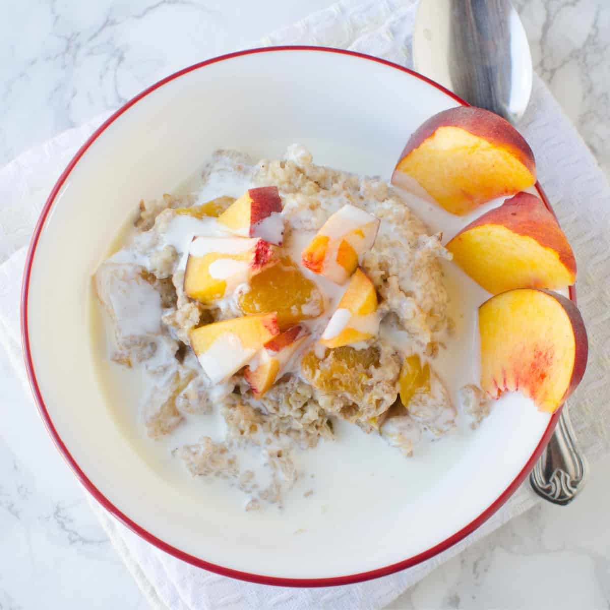 peaches and cream in a white bowl with sliced peaches