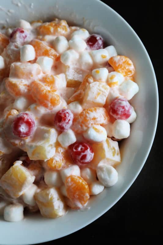Marshmallow Fruit Salad in a white serving bowl with a black background