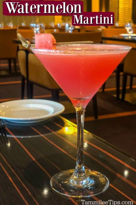 Watermelon Martini text over a pink red martini with a watermelon garnish on a table next to a plate