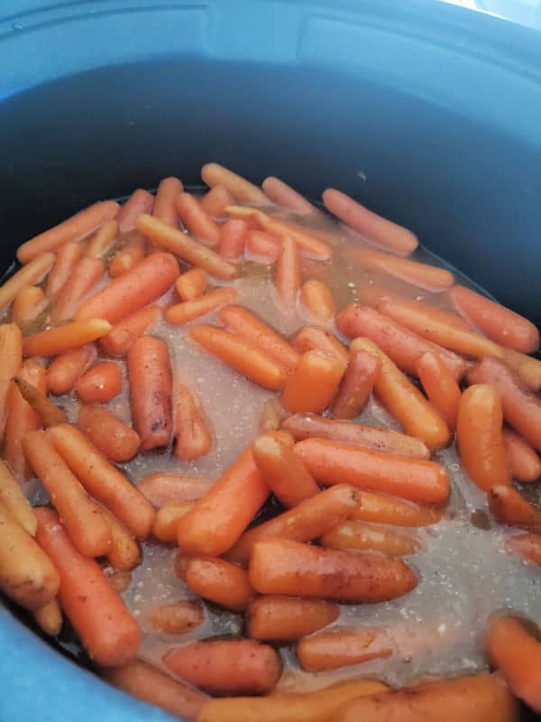 crock pot carrots in a black crock pot cooking