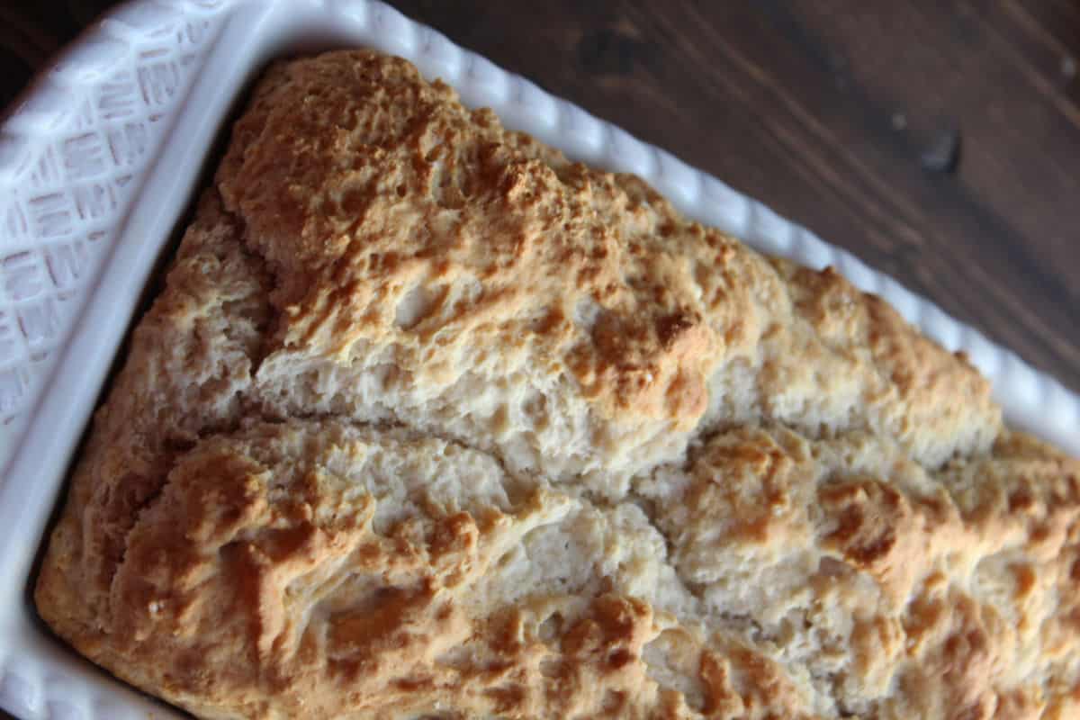 beer bread in a white pan on a wood board