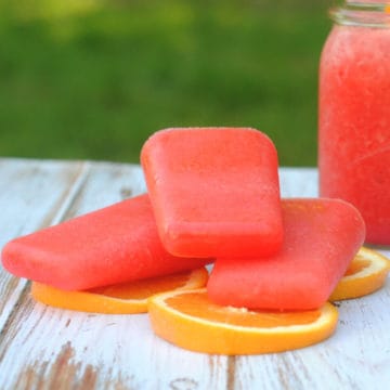Hurricane Popsicles stacked on orange slices on a picnic table