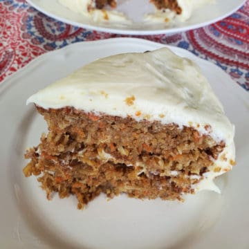 Slice of Carrot Cake with Pineapple, Coconut and Port Wine and cream cheese frosting on a white plate