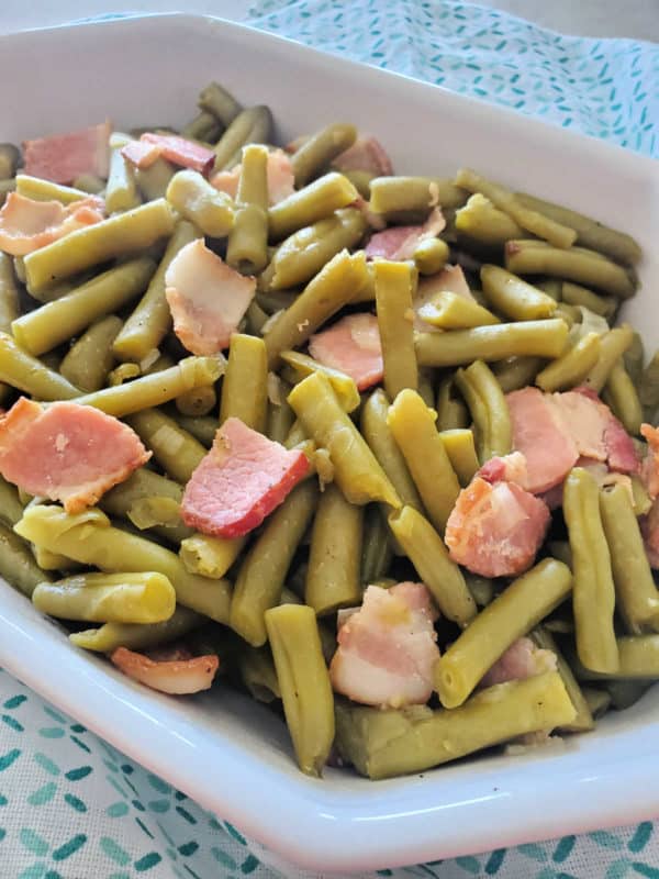 green beans and bacon in a white serving dish