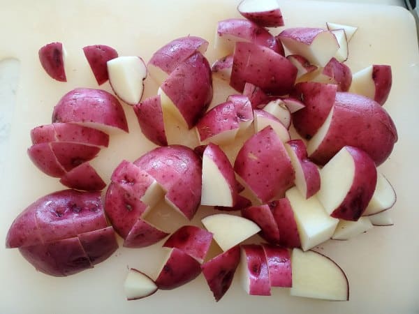 cut up red potatoes on a cutting board