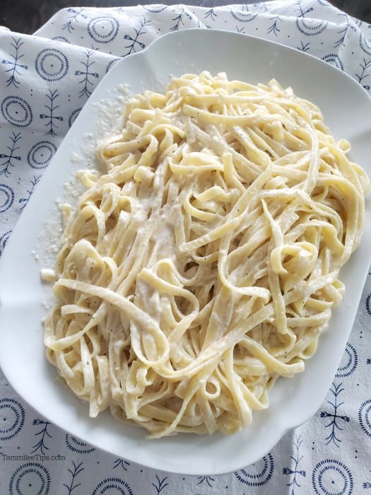 Olive Garden fettuccine alfredo on a white platter with a cloth napkin