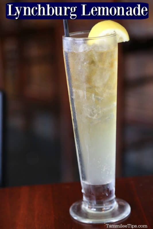 Lynchburg Lemonade text over a tall glass of lemonade with a lemon wedge