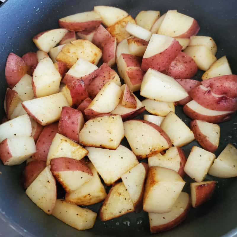 Seasoned red breakfast potatoes in a dark skillet