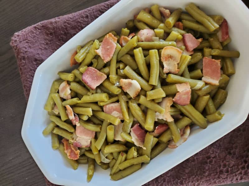 Cracker Barrel Green beans with bacon in a white serving dish on a brown napkin