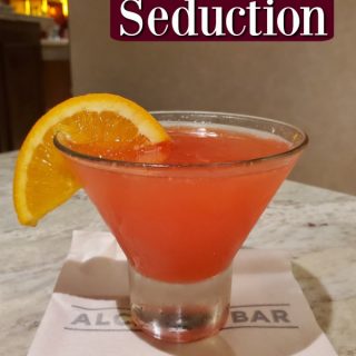 Martini Seduction text over a pink martini with an orange wedge garnish