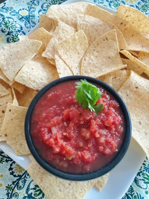 Chili's salsa copycat recipe in a black bowl surrounded by tortilla chips