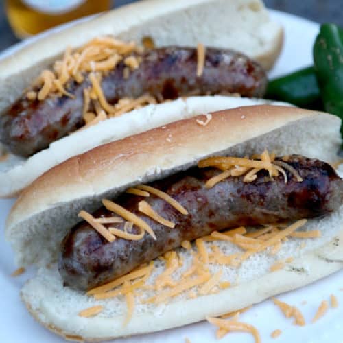 two jalapeno beer brats on buns with shredded cheese