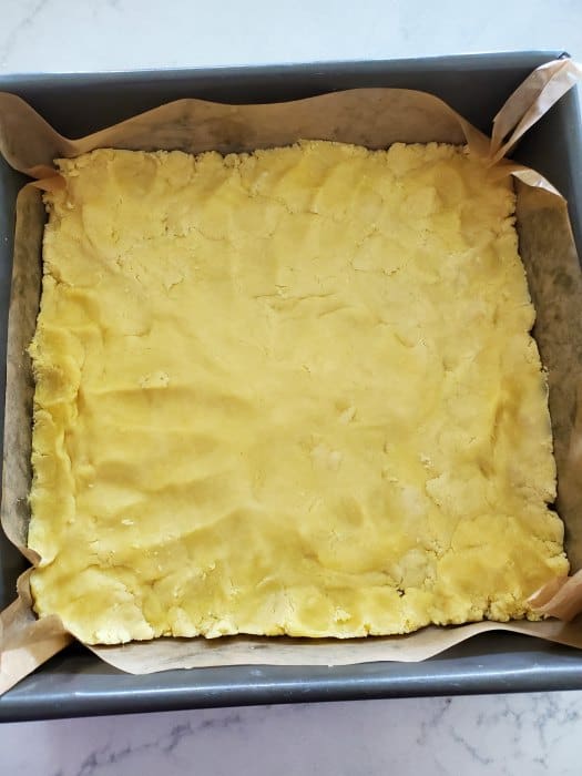 dough pressed into a parchment lined baking sheet. 