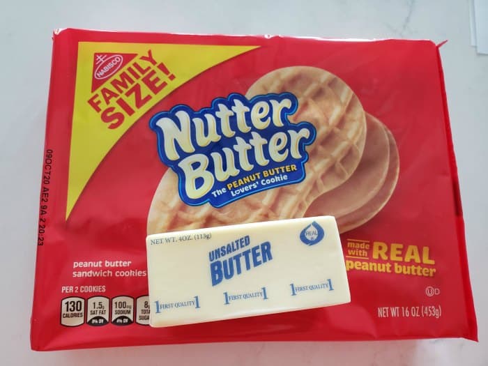 Family size Nutter Butter package and a stick of butter on a white counter. 