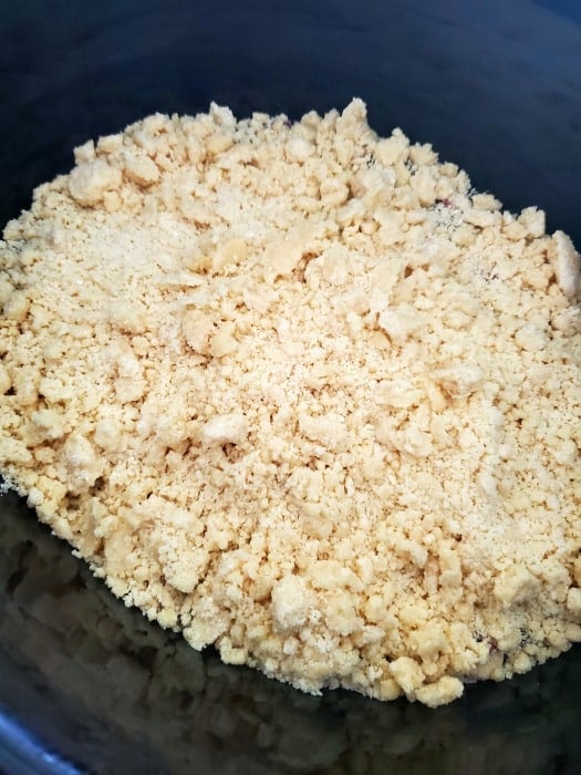 Cake crumble over blueberry mix in a slow cooker