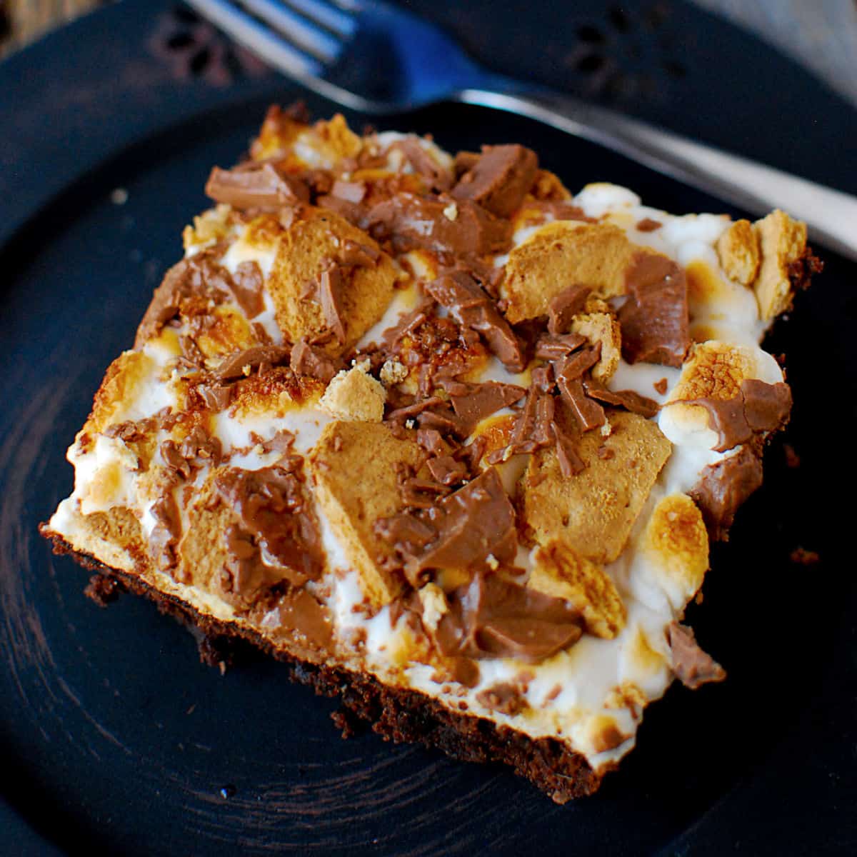 Smores Brownie Square on a dark plate next to a fork