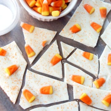 candy corn bark on parchment paper next to a bowl of candy corn