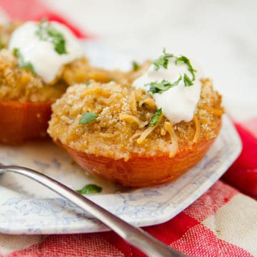 Stuffed tomatoes with cheese and sour cream on a white and blue plate