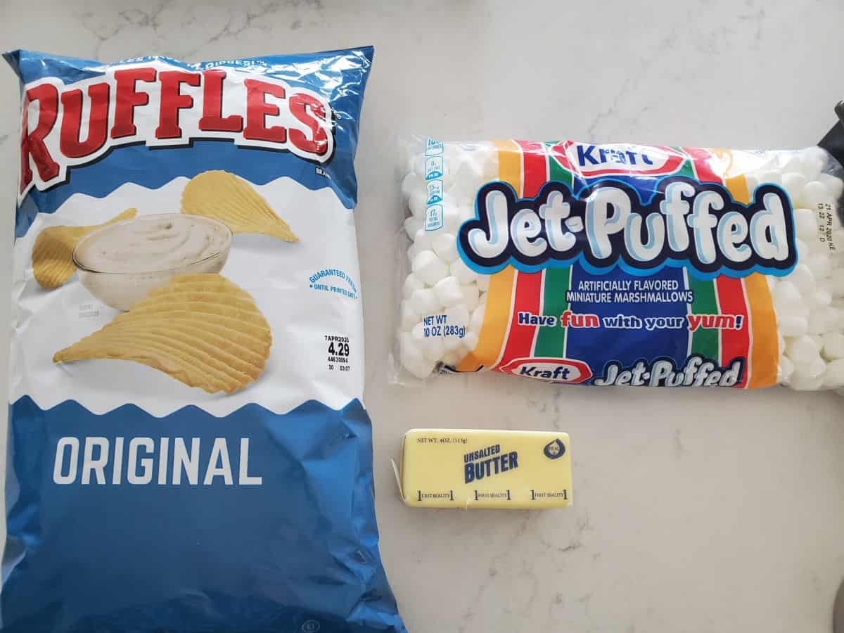 Ruffles Original Potato Chips bag, stick of butter, and bag of mini marshmallows on a white counter