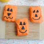 pumpkin rice Krispie jack o lanterns on a wood cutting board