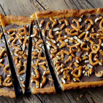 Sweet and Salty Chocolate Dessert Bar topped with pretzel on a wood board.