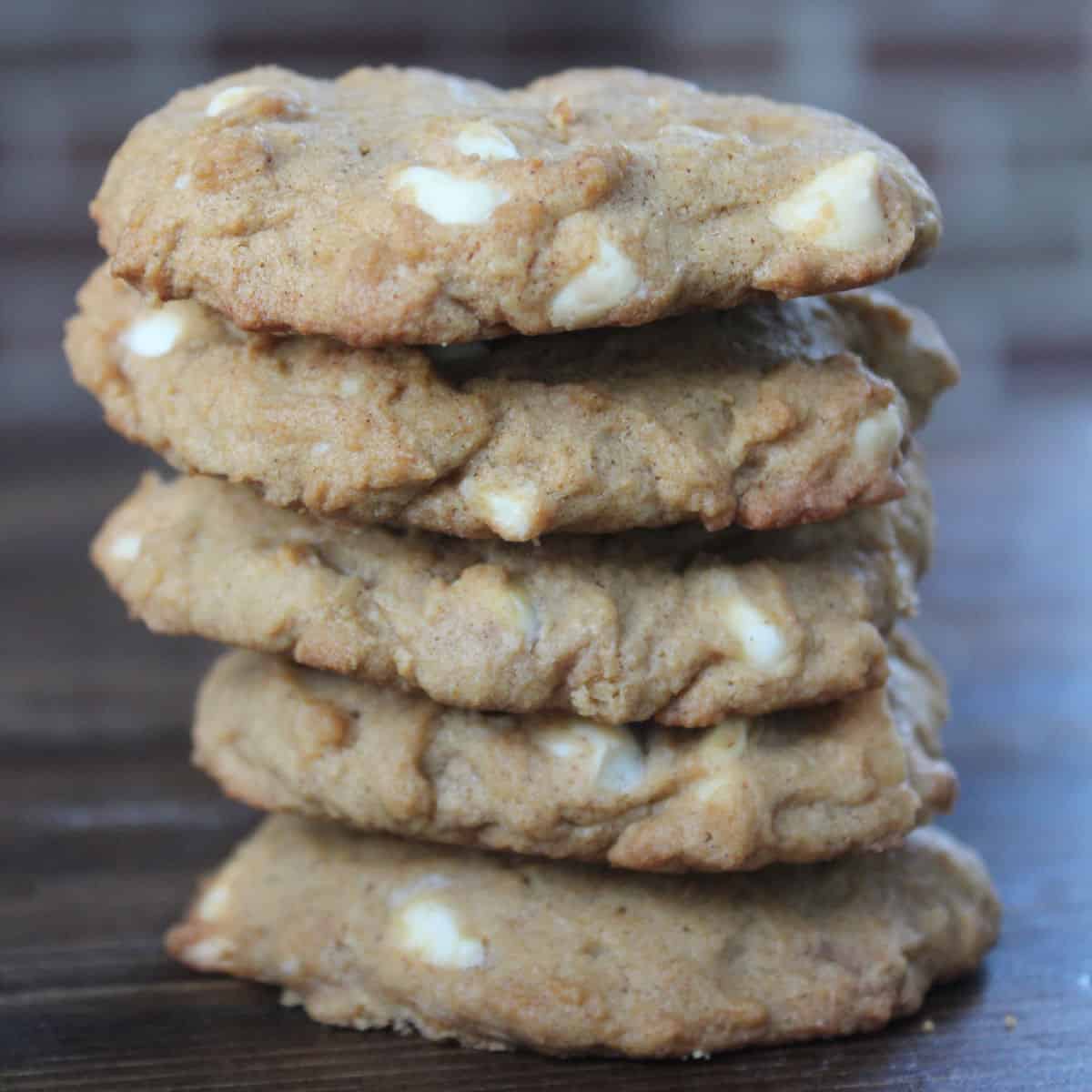 Stack of White Chocolate Pumpkin Spice Cookies on a wood board