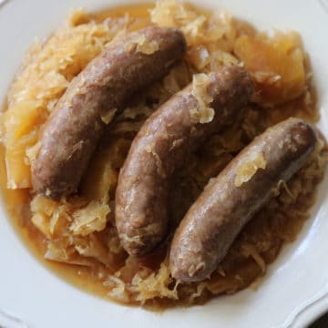 crockpot brats and sauerkraut on a white plate