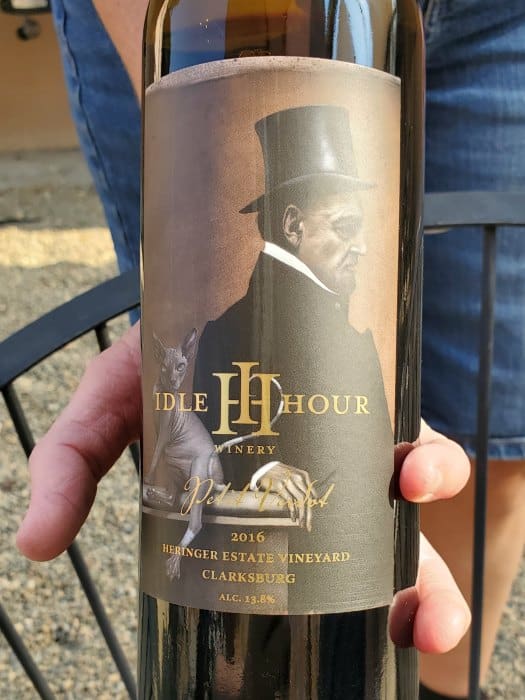 Bottle of Idle Hour Winery wine with a hairless cat and man wearing a top hat on the label