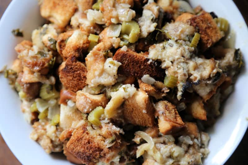 Slow cooker stuffing in a white bowl with bread and celery