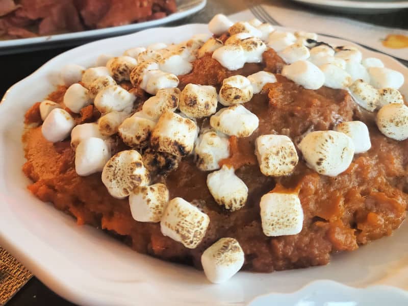 crockpot sweet potato casserole with toasted marshmallows in a white bowl 