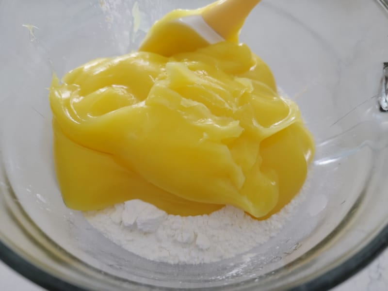 Lemon Pie Filling on top of Angel Food Cake mix in a glass bowl for lemon bars with cake mix