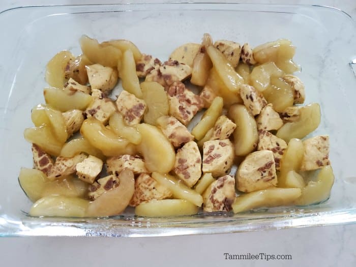 Cinnamon roll pieces and apples in a glass baking dish