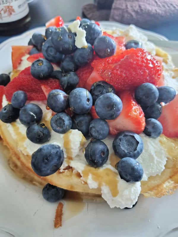 Bisquick Waffle with whipped cream, blueberries, strawberries, and syrup