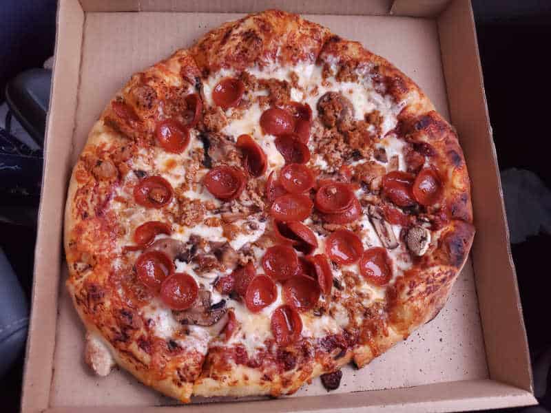 Pepperoni and sausage pizza in a cardboard delivery box