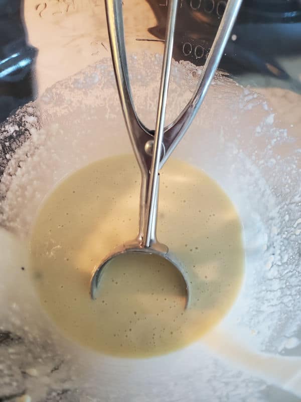 Cookie scoop in a bowl of muffin mix pancake batter