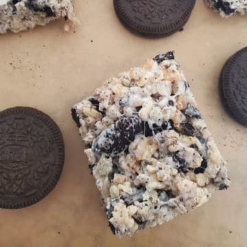 Oreo Rice Krispie Treats on parchment paper next to Oreo Cookies