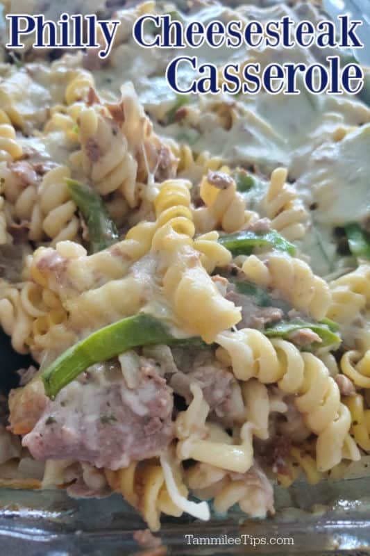 Philly Cheesesteak Casserole over a glass baking dish with cheesesteak, pasta, cheese, and green peppers
