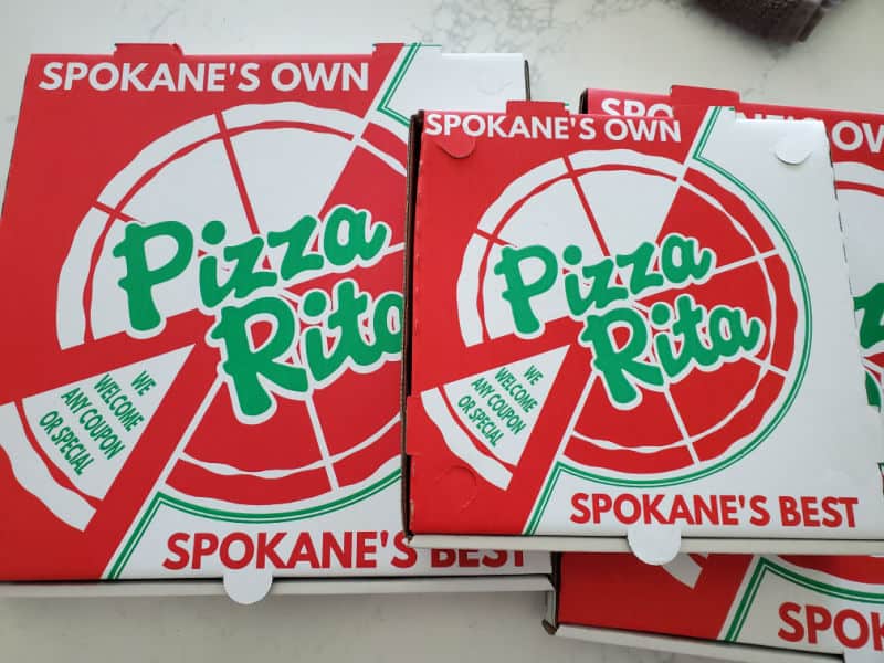 Three Pizza Rita boxes on a white counter