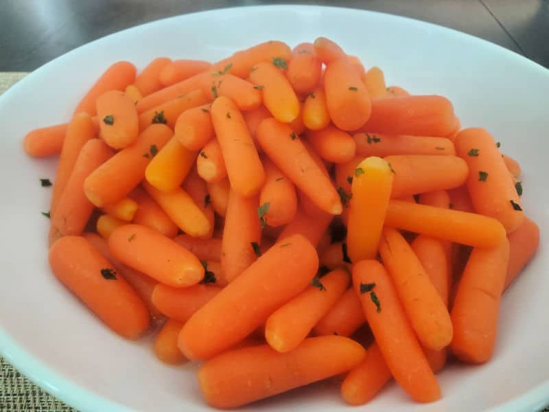 Cracker Barrel Carrots in a white serving bowl on a dark table