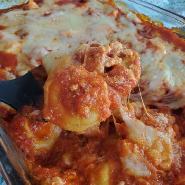 black spoon scooping lazy lasagna from a glass casserole dish