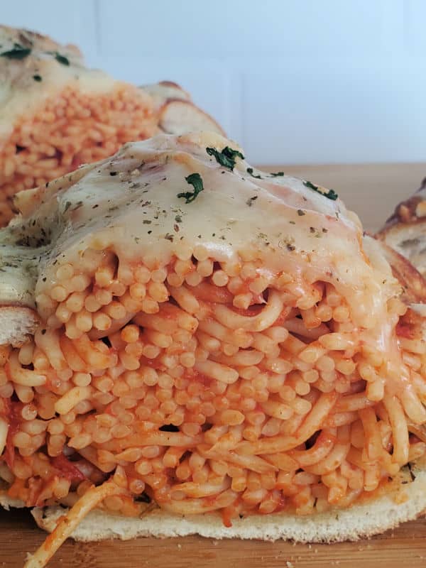 Spaghetti Stuffed Garlic Bread on a wood cutting board