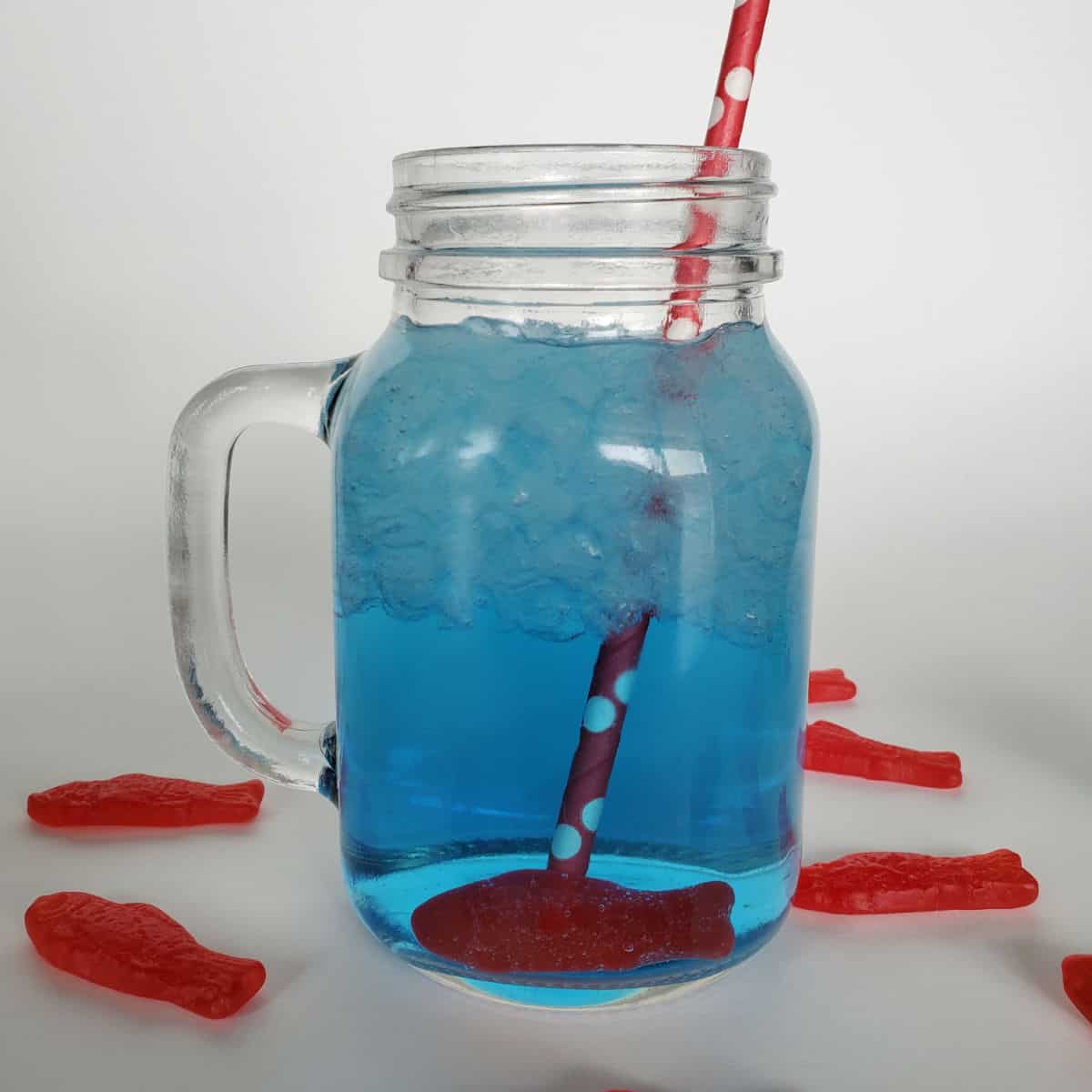 Sonic ocean water in a mason jar with a Swedish fish candy and red straw