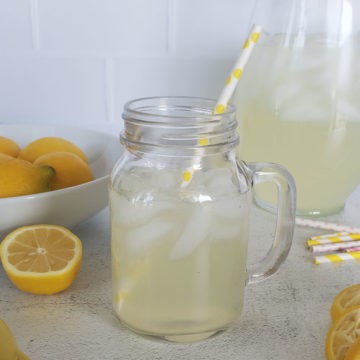 Chick Fil A Lemonade in a mason jar glass in front of a pitcher and lemons
