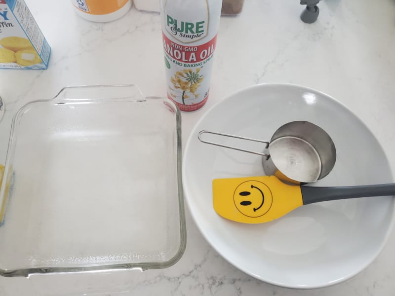 baking dish, spatula, measuring cup, and bowl on a white counter